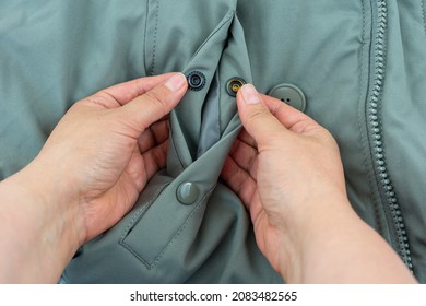 Two collapsible parts of the unbuttoned metal snap button fastener, mounted on the outerwear olive color close-up. - Shutterstock ID 2083482565