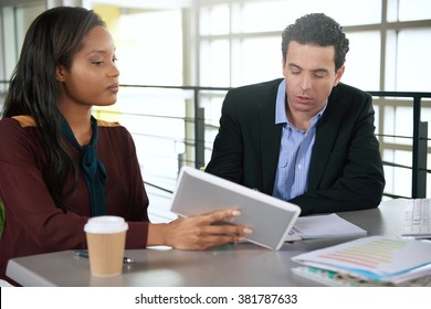 Two  colleages discussing ideas using a tablet 
