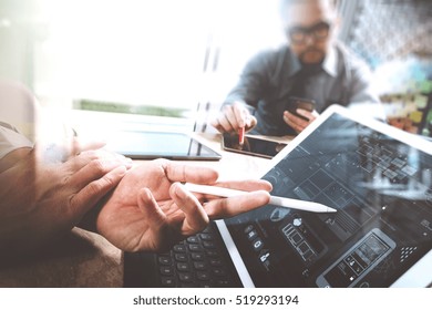 Two Colleague Web Designer Discussing Data And Digital Tablet Docking Keyboard And Computer Laptop With Smart Phone And Design Diagram On Marble Desk,sun Light Effect