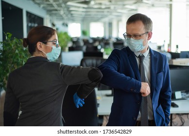 Zwei Kollegen vermeiden Handschlag bei einem Treffen im Büro und grüßen hüpfende Ellenbogen. Grüße in Wuhan. Ein Mann und eine Frau in medizinischen Masken halten eine soziale Distanz bei der Arbeit.