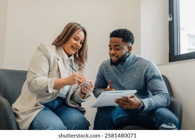 Two colleagues collaborating, taking notes and sharing ideas during a productive meeting in a modern office