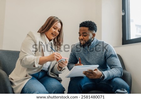 Two colleagues collaborating, taking notes and sharing ideas during a productive meeting in a modern office