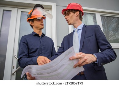 Two Colleagues Discuss Using A Floor Plan, Engineers At Work
