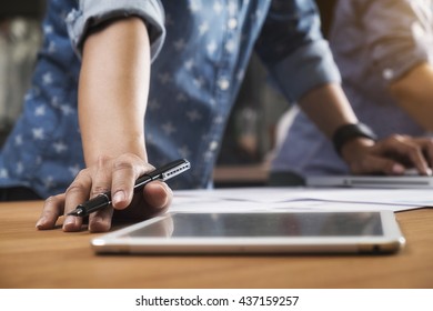 Two colleagues discussing data with new modern computer laptop and pro digital tablet with digital business strategy layer effect on wooden desk as concept. - Shutterstock ID 437159257