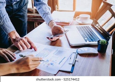Two colleagues discussing data with smart phone and new modern computer laptop on desk table. Close up business team analysis and strategy concept. - Shutterstock ID 525174412