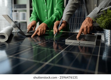 Two colleagues discussing data working and tablet, laptop with on Construction Site project, green energy and solar panel concept.