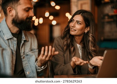 Two colleagues discussing work at a cafe, collaborating and communicating