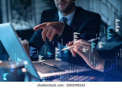Two colleagues in formal wear working together to optimize trading strategy at corporate finance fund. Forex chart hologram over modern office background - Shutterstock ID 2003398163