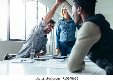 Two Colleagues Giving High Five In Meeting. Business People Celebrating Success In Conference Room.