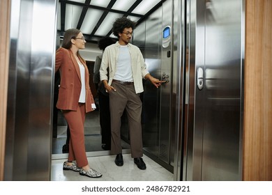 Two colleagues, one with a prosthetic leg, chat in an elevator, waiting for their floor. - Powered by Shutterstock