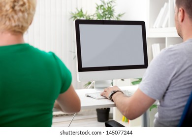 Two  Colleagues At Work  In  Front Of Computer Screen