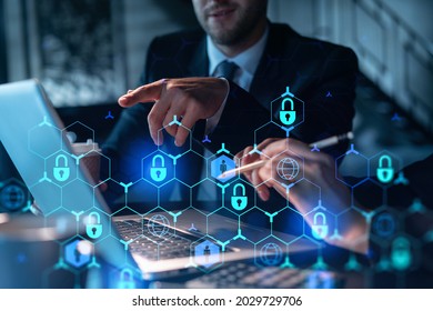 Two colleagues working together to protect clients confidential information and cyber security. IT hologram padlock icons modern office background at night time - Powered by Shutterstock