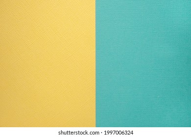 Two colored papers with a blue and yellow overlay on the floor. they divide half of the image. Dual background, flat lay