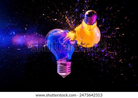 Two colorful light bulbs exploding  black background creativity concept