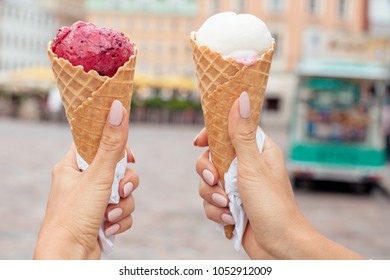 Two Colorful Tasty Ice Cream Cones In Hands