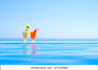 Two Colorful Tropical Cocktails Near The Swimming Pool On The Background Of Warm Blue Sea. Exotic Summer Vacation.