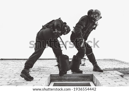 Two commandos train at the base. Climbers. SWAT, police, counterterrorism concept. Mixed media