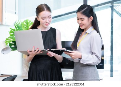 Two Company Employees One Person Holding A Laptop And The Other Holding A Note Board Where The Two Of Them Were Meeting To Discuss The Operation Of The Financial System. 