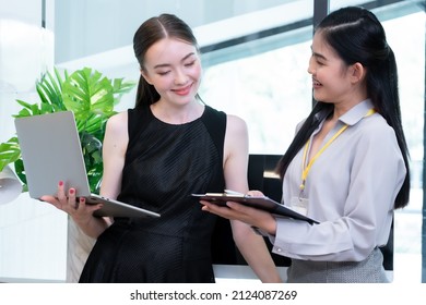 Two Company Employees One Person Holding A Laptop And The Other Holding A Note Board Where The Two Of Them Were Meeting To Discuss The Operation Of The Financial System.