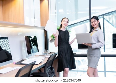 Two Company Employees One Person Holding A Laptop And The Other Holding A Work Document Where The Two Of Them Were Meeting To Discuss The Operation Of The Financial System.