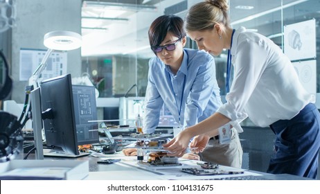 Two Computer Engineers Choose Printed Circuit Boards to Work with. In The Background Technologically Advanced Scientific Research Center.