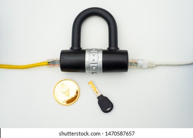 Two computer network cables going through a lock with a key and a crypto currency coin, depicting digital security, cybersecurity or internet security