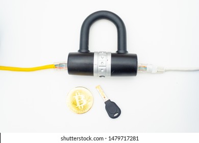 Two computer network cables going through a lock with a key and a crypto currency coin, depicting digital security, cybersecurity or internet security