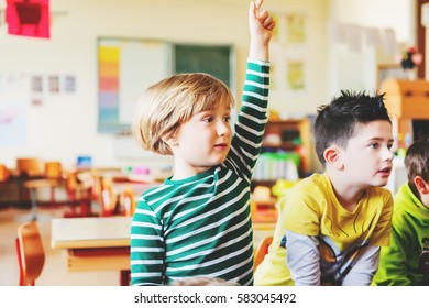 Two Concentrated 4-5 Year Old Boys In Classroom, Kid Raising Hand On Lesson