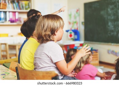 Two concentrated 4-5 year old boys in classroom - Shutterstock ID 666980323