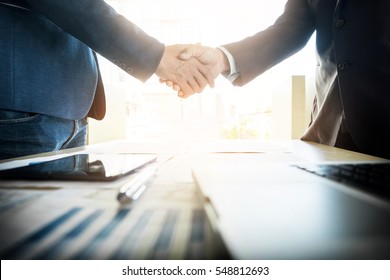 Two confident business man shaking hands during a meeting in the office, success, dealing, greeting and partner concept. - Shutterstock ID 548812693