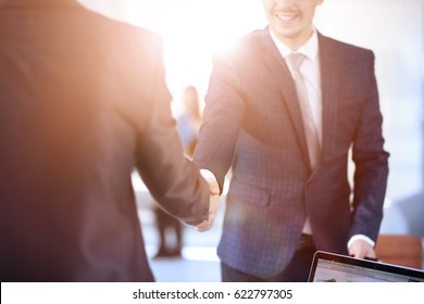 Two confident business man shaking hands during a meeting in the office, success, dealing, greeting and partner concept.
