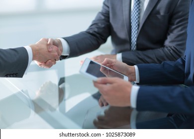 Two confident businessmen shaking hands during a meeting in the - Powered by Shutterstock