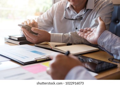 Two confident executives business colleagues meeting and discussing ideas of project about company offer, they is pointing on a contract and giving explanations, team of successful business people. - Shutterstock ID 1022916073
