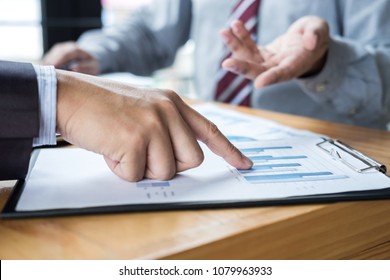 Two confident executives business colleagues meeting and discussing ideas of project about company offer, they is pointing on a contract and giving explanations, team of successful business people. - Shutterstock ID 1079963933