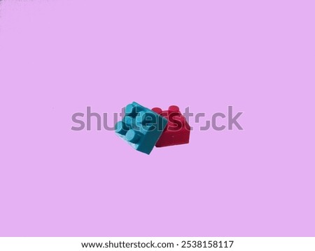 Two constructor lego bricks on a pink background