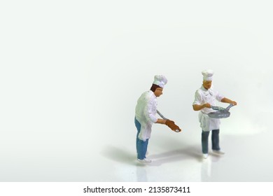 Two Cooks In Work Clothes And Cookware On White Background. Closeup