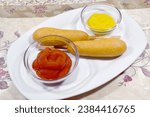 Two Corndogs with Mustard and Ketsup	