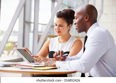 Two Corporate Business Colleagues Working Together In Office