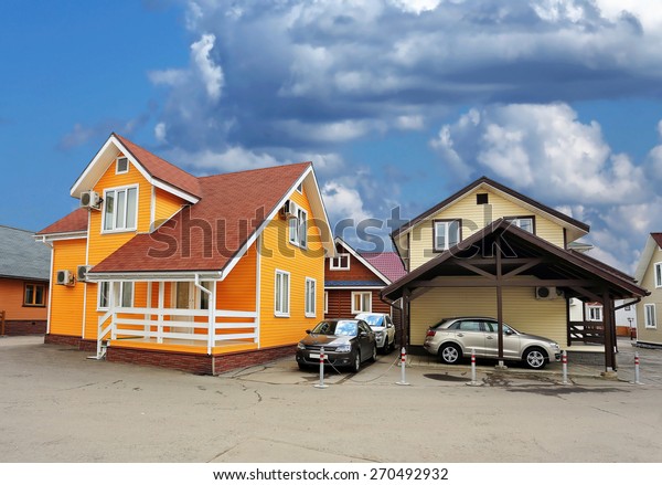 Two cottages and autos\
parked nearby