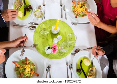 Two Couples Dining In Fine Restaurant Enjoying The Good Food