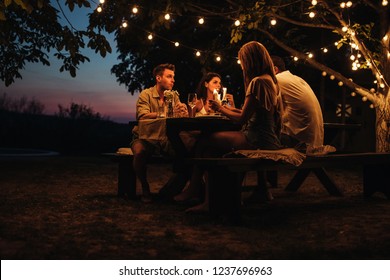 Two couples having a romantic dinner outdoors - Powered by Shutterstock