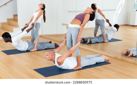 Two couples of young adult people practicing yoga lesson with partner at studio - Powered by Shutterstock