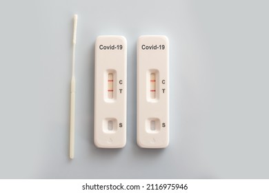 Two Covid Antigen Rapid Test Kits And A Nasal Swab With Positive Results On White Background, Covid-19 Lab Testing Concept