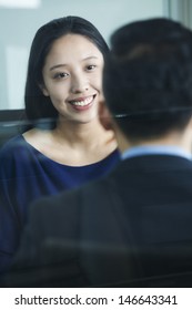 Two Co-workers Talking In Office