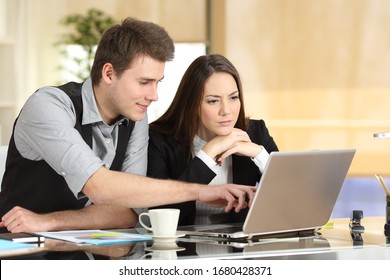 Zwei Mitarbeiter arbeiten zusammen, prüfen den Inhalt von Notebooks und sprechen im Büro darüber