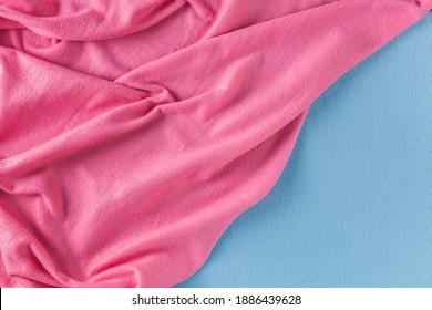 Two cozy plaid made of blue and pink fabric with a pile lies in beautiful folds. Texture of soft blanket with fluffy pile.