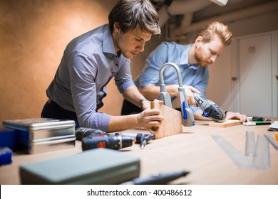 Two Creative Designers Working In Workshop And Creating Custom Furniture