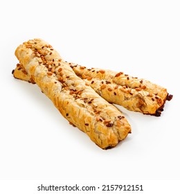 Two crispy appetizing pigtail made of puff pastry with sunflower seeds, close-up. White background.