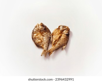 Two crispy yellow fried fish are placed on a white background. - Shutterstock ID 2396432991