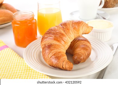 Two croissants, jam and juice for breakfast.